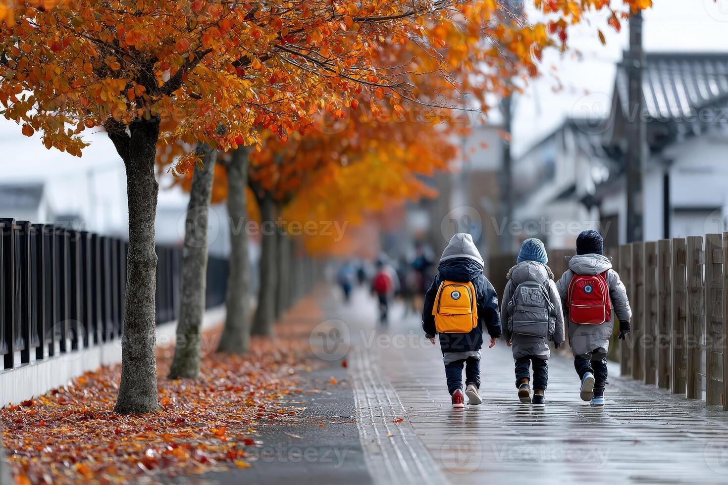 Children walking along a tree-lined street with autumn leaves in a vibrant neighborhood photo
