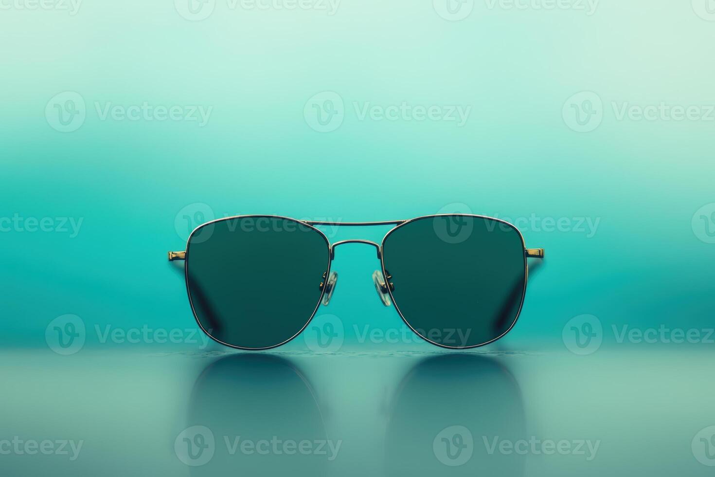 Stylish sunglasses with dark lenses set against a vibrant teal background photo