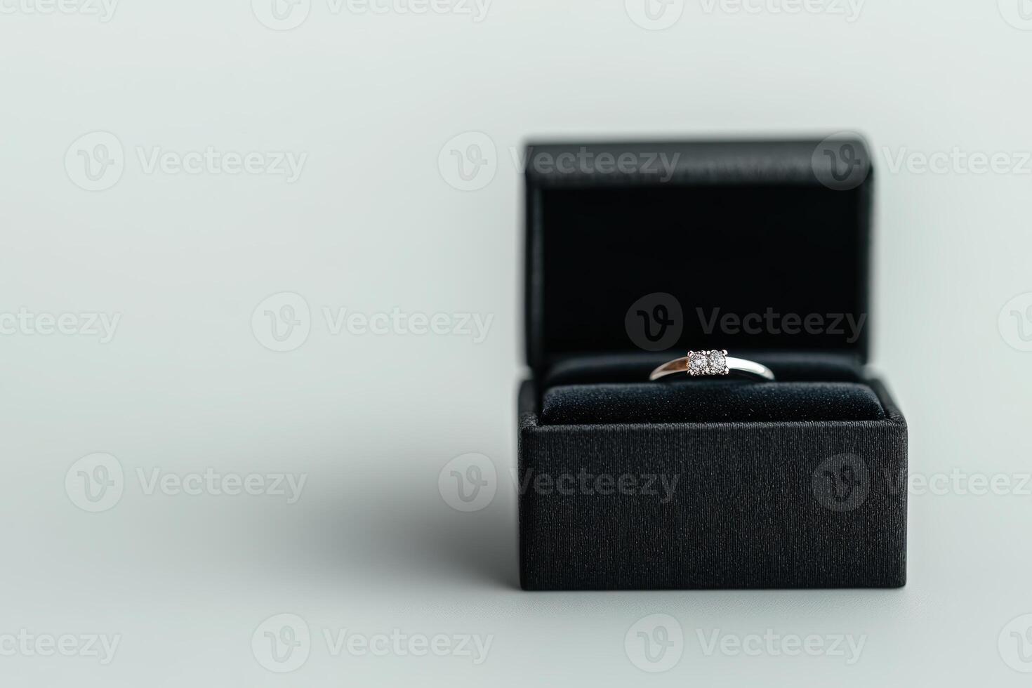 Elegant silver ring displayed in a plush black box on a soft grey background photo