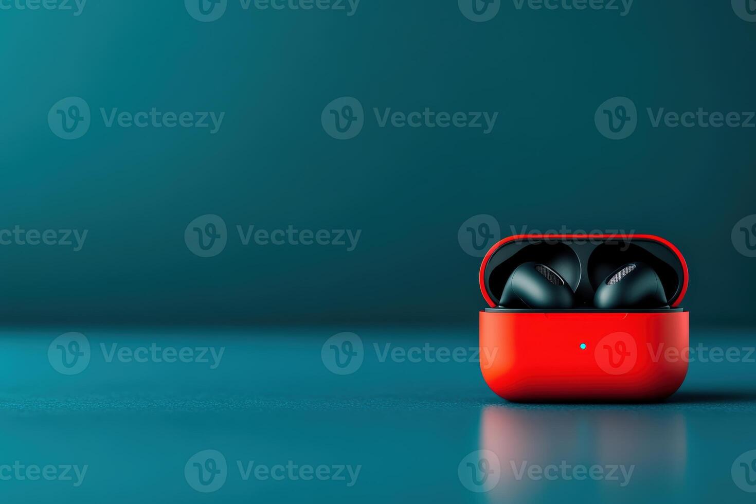 Wireless earbuds charging in a vibrant red case on a sleek blue surface photo