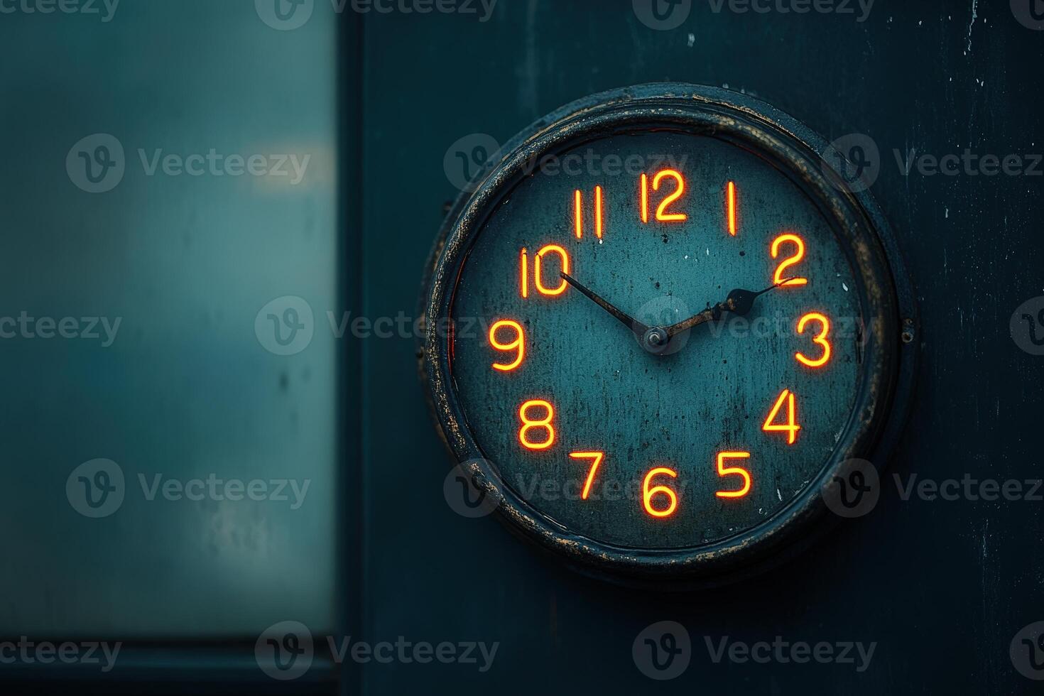 Vintage wall clock showing time with glowing numbers in a dimly lit room photo