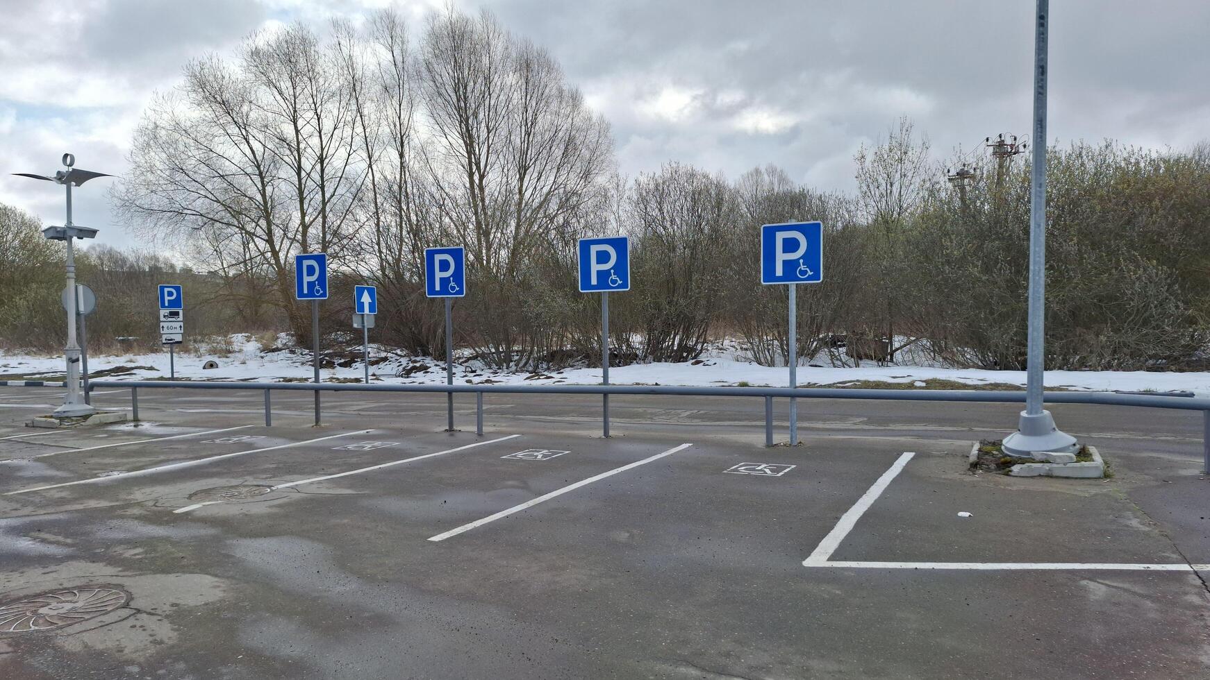 Moscow region, Russia - April 12, 2025.Snow empty parking for people with disabilities photo