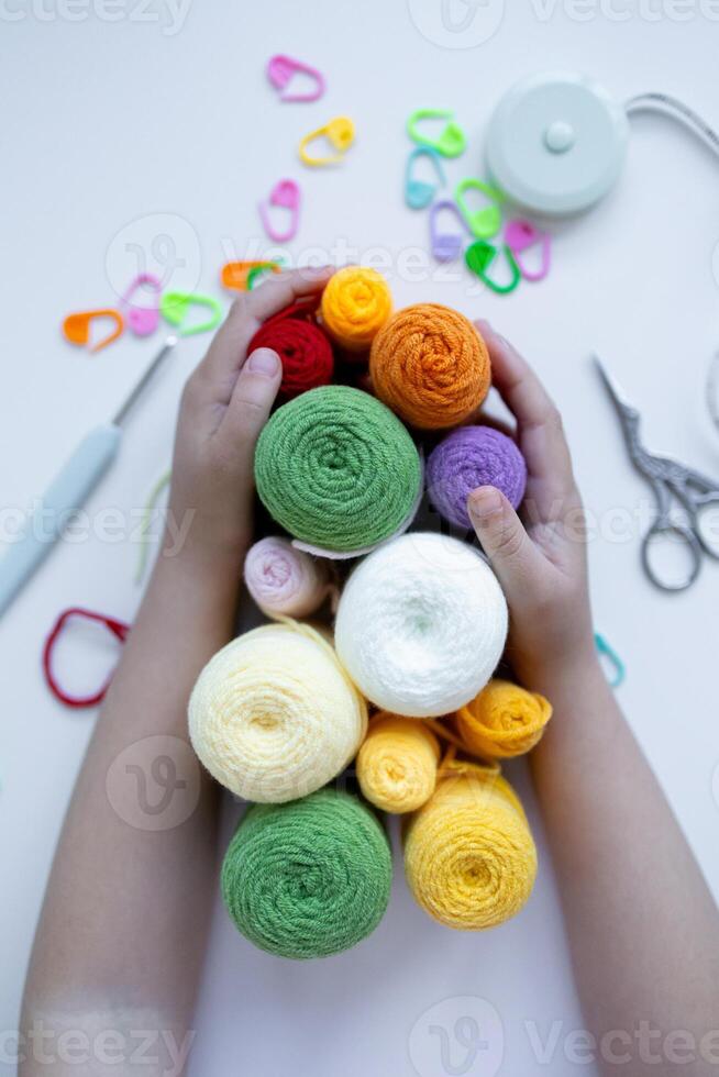 Child hands hold colorful yarn in creative crafting activity photo