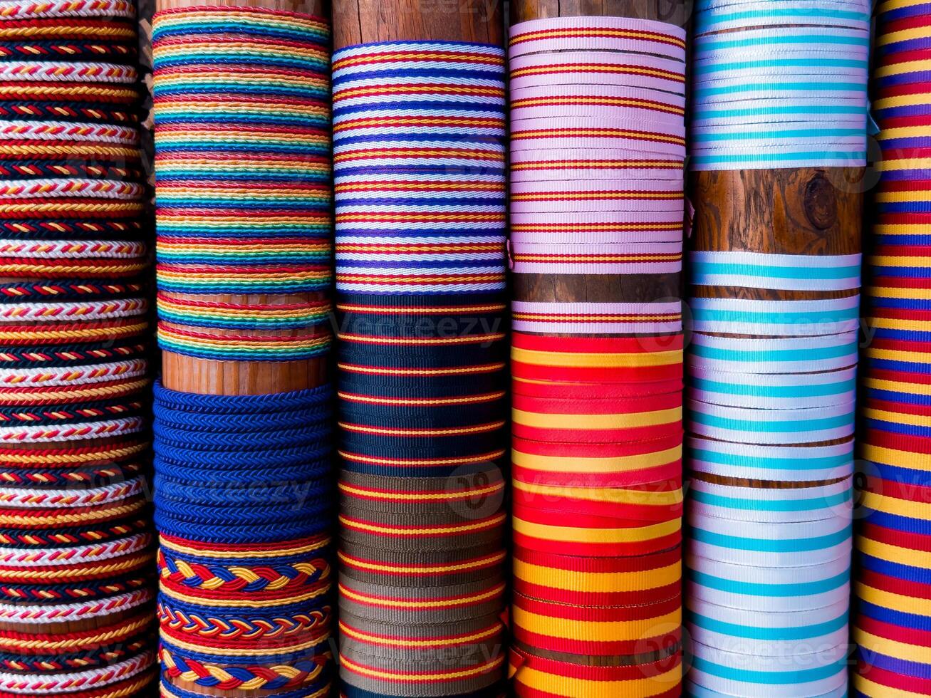 Colorful rolled fabric display with various patterns and textures photo