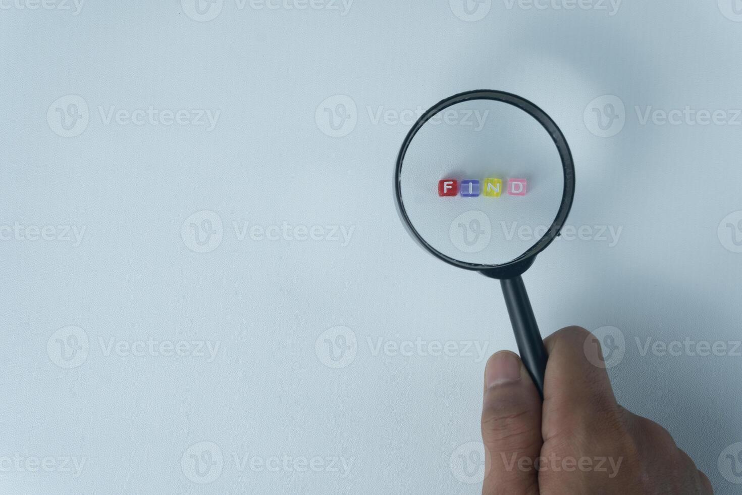 Word Find Formed by Letter Beads Under Magnifying Glass on Light Blue Background photo