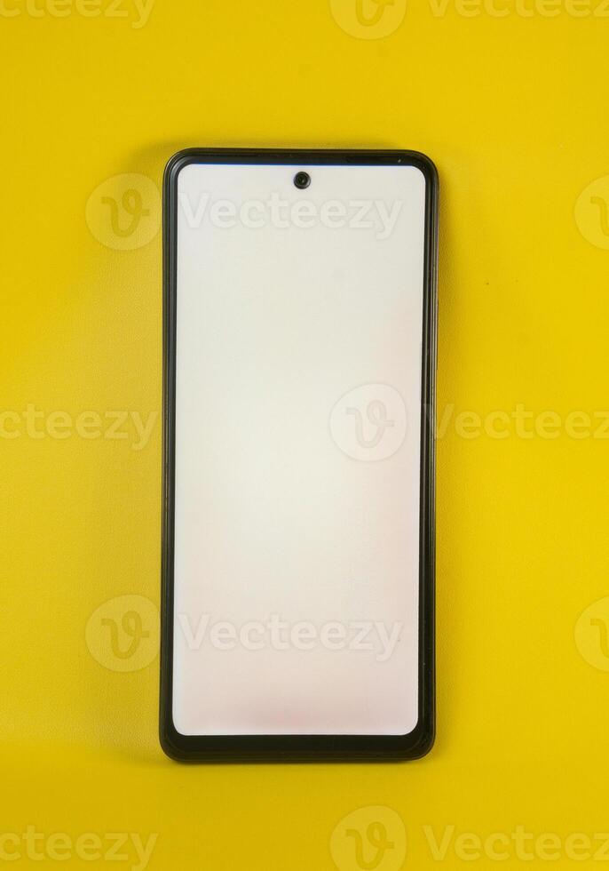 Smartphone with a blank screen against a vertical yellow background photo