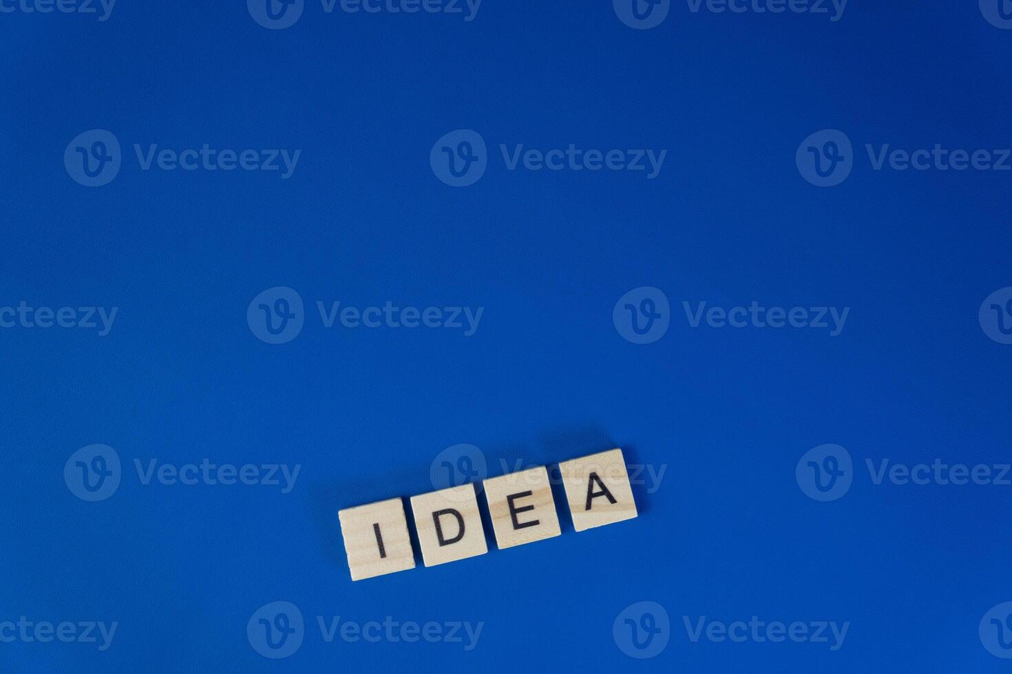 Word IDEA Made of Wooden Letter Tiles on Blue Background Creative Thinking Concept photo