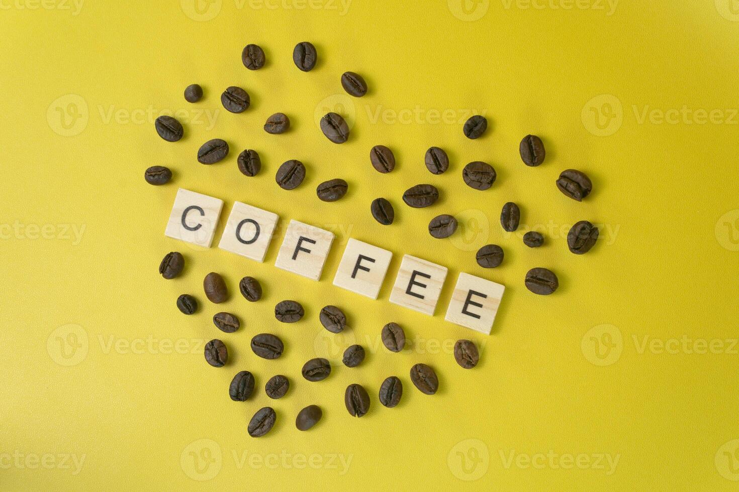 Word COFFEE Surrounded by Coffee Beans in Heart Shape on Yellow Background Love for Coffee Concept photo