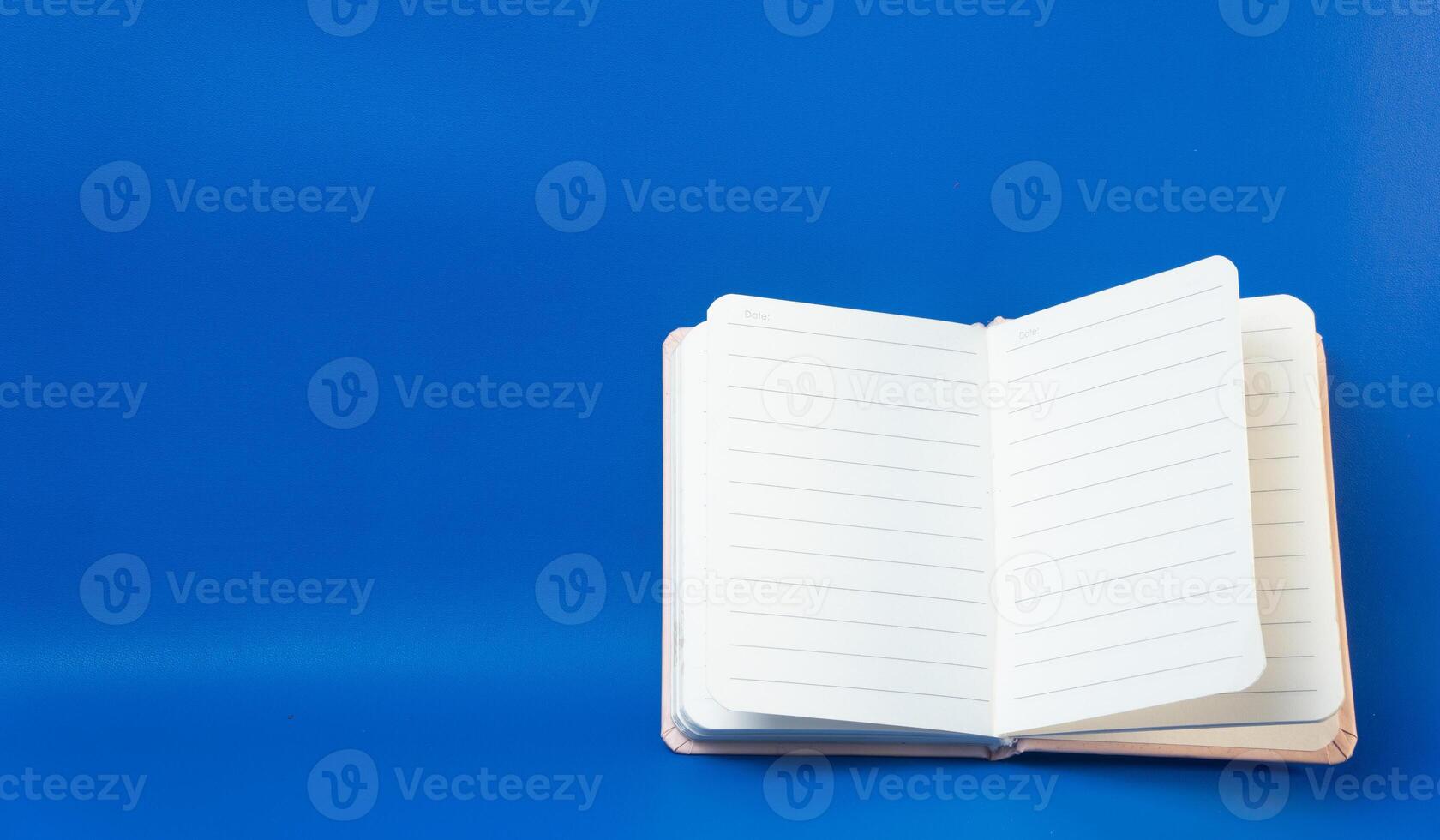 Open notebook with blank pages on a blue background photo