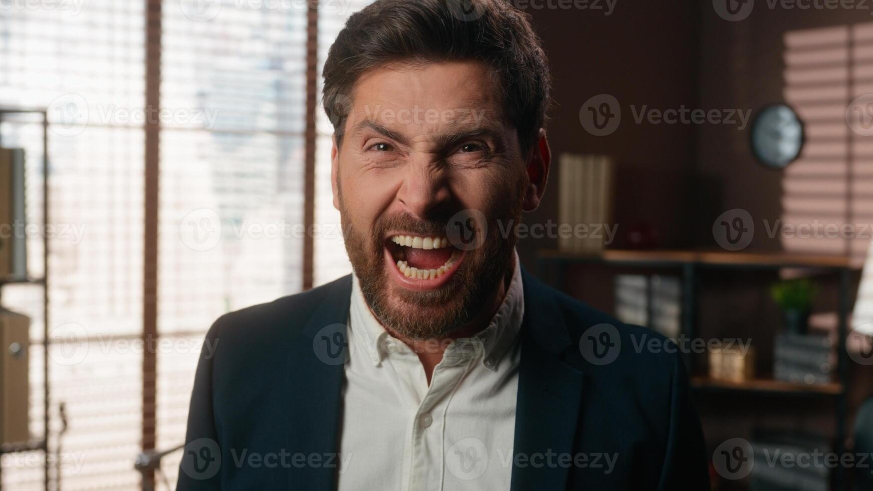 Angry furious mad stressed European business man in office yelling screaming shouting looking at camera yell anger rage emotion overworked problem scream male employer guy entrepreneur businessman photo
