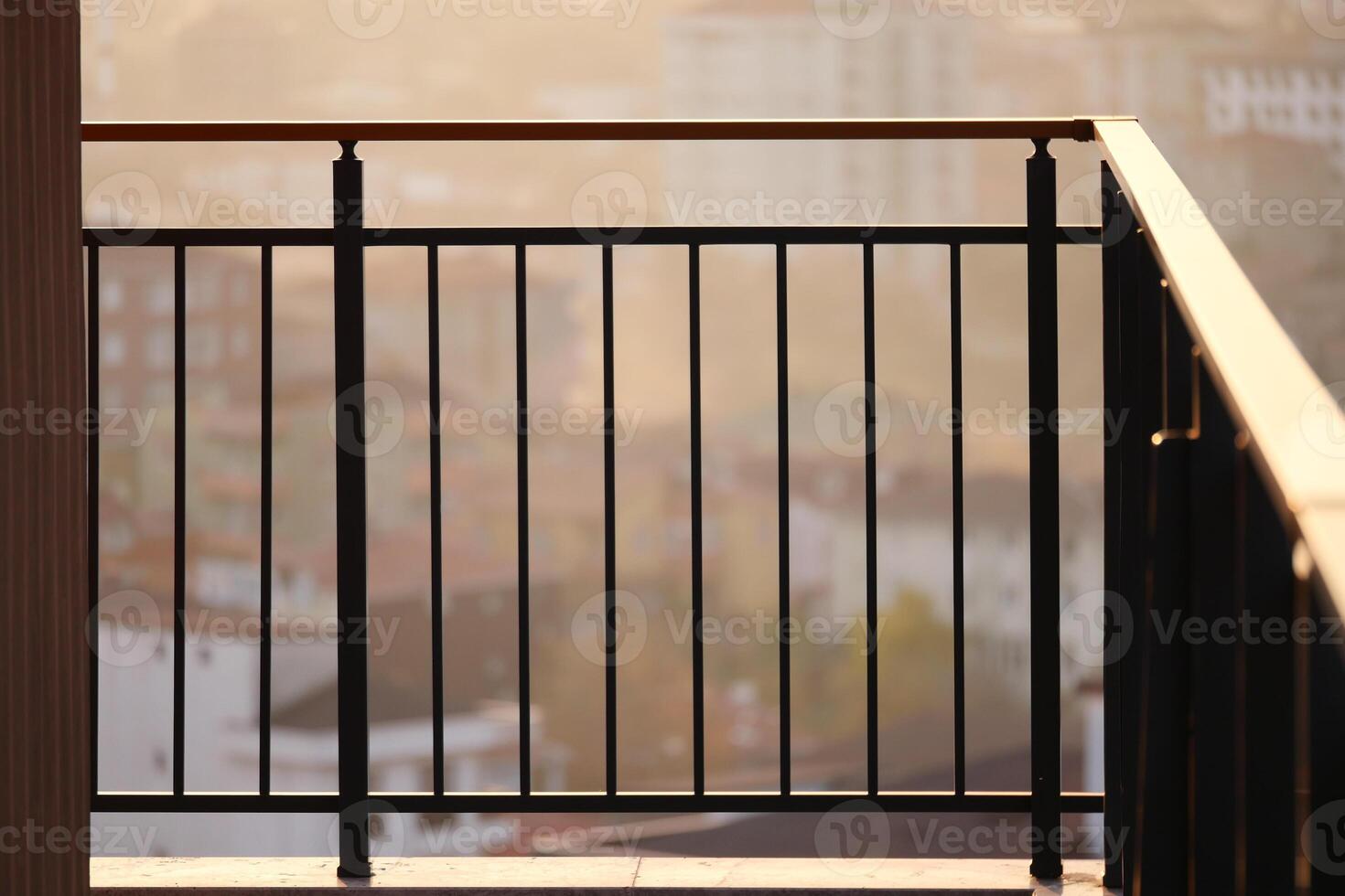 Balcony overlooking cityscape at sunset with warm golden light photo