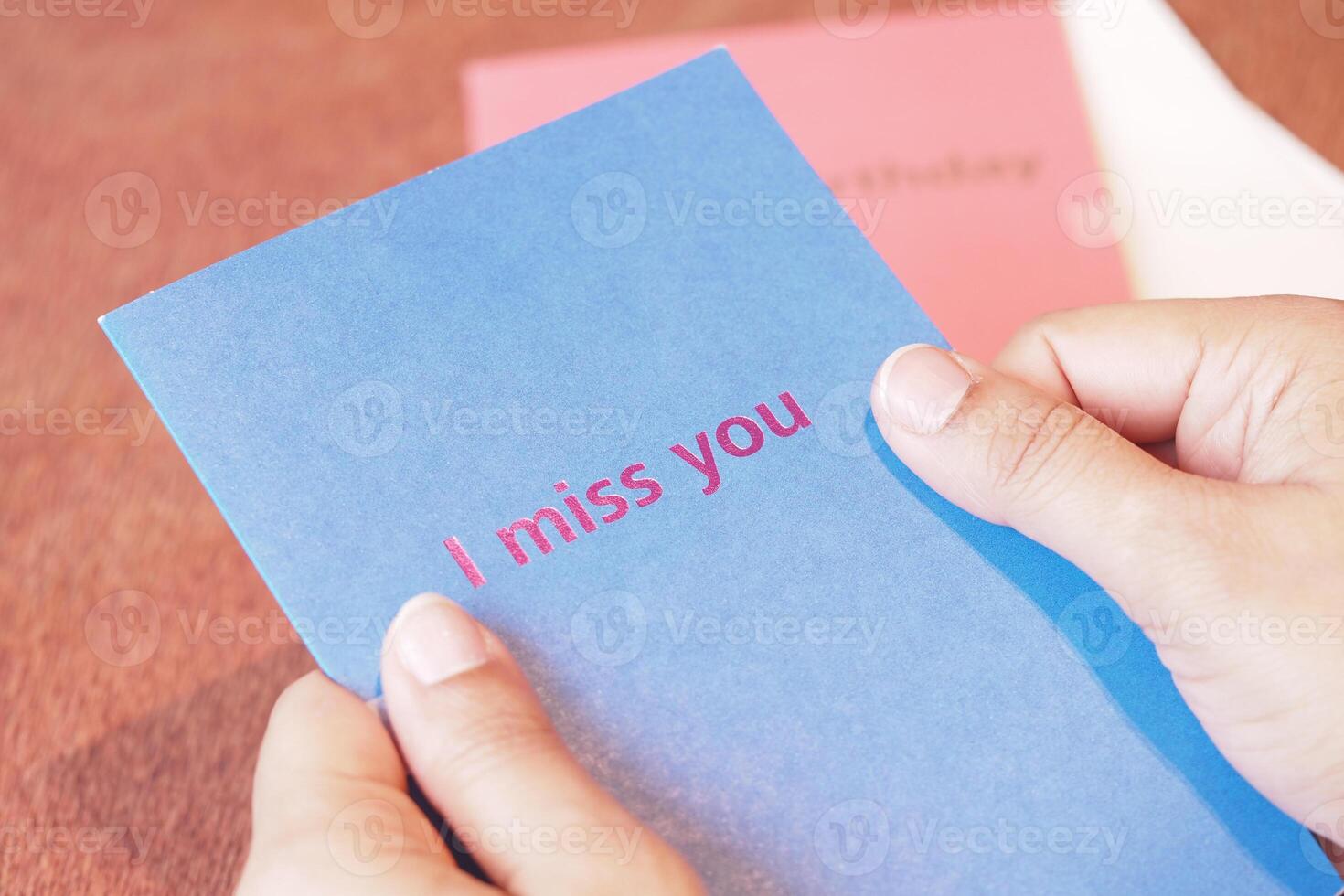 Person holding a card that expresses feelings of missing someone photo