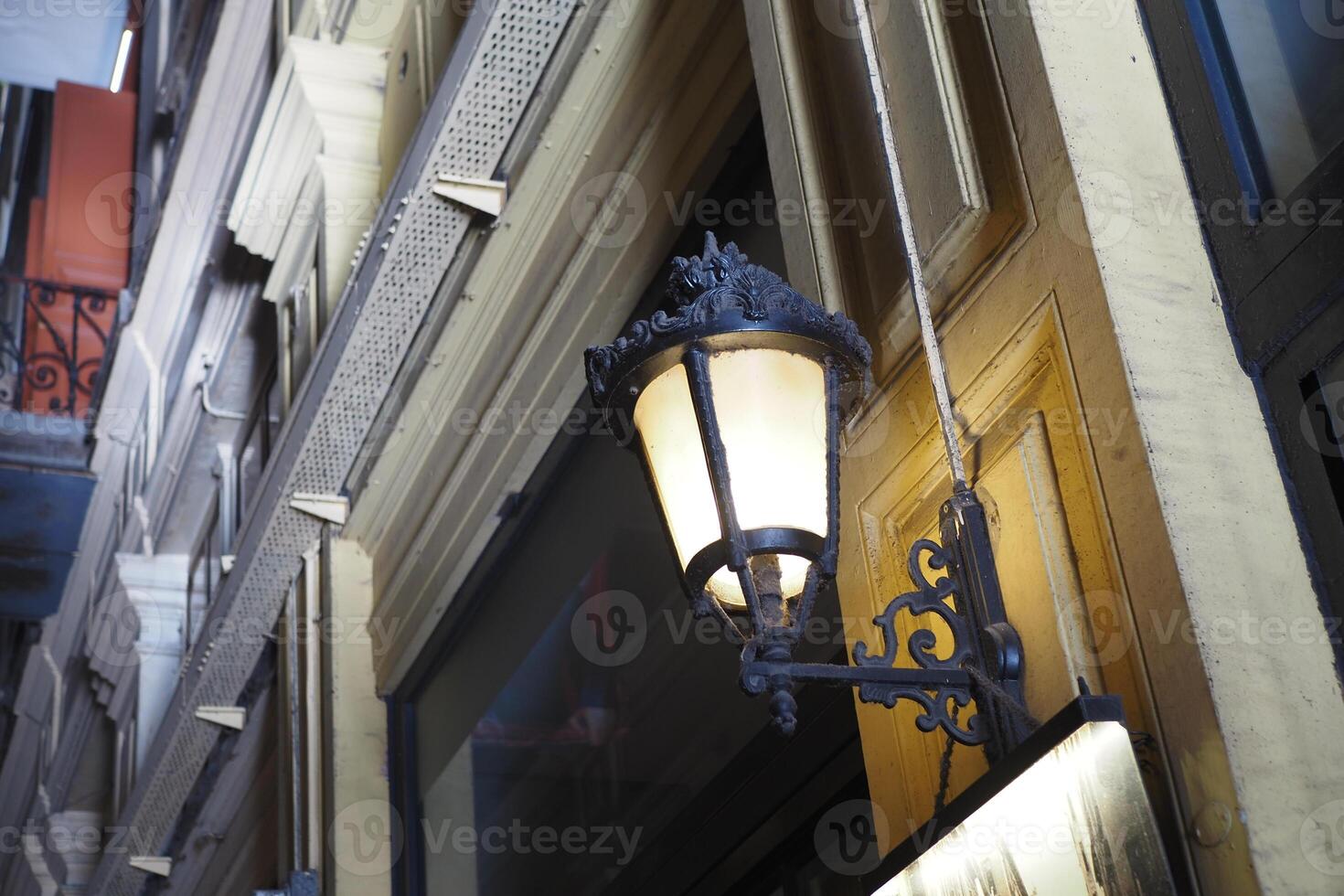 Charming vintage street lamp hanging outside a European building photo