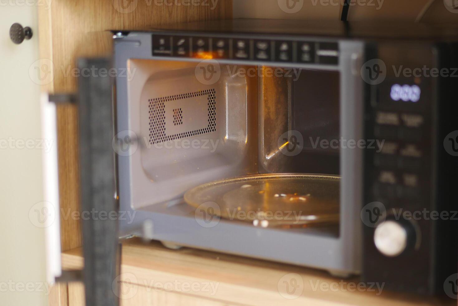 Microwave oven on a kitchen counter with an open door photo