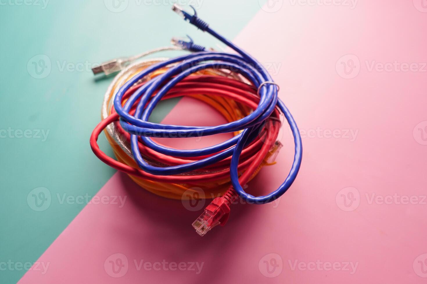 Colorful cables bundled together on a pastel background photo