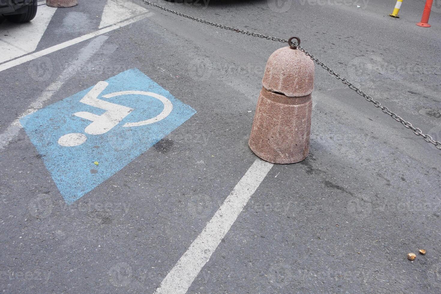 Concrete barrier blocks access to handicapped parking space on street photo