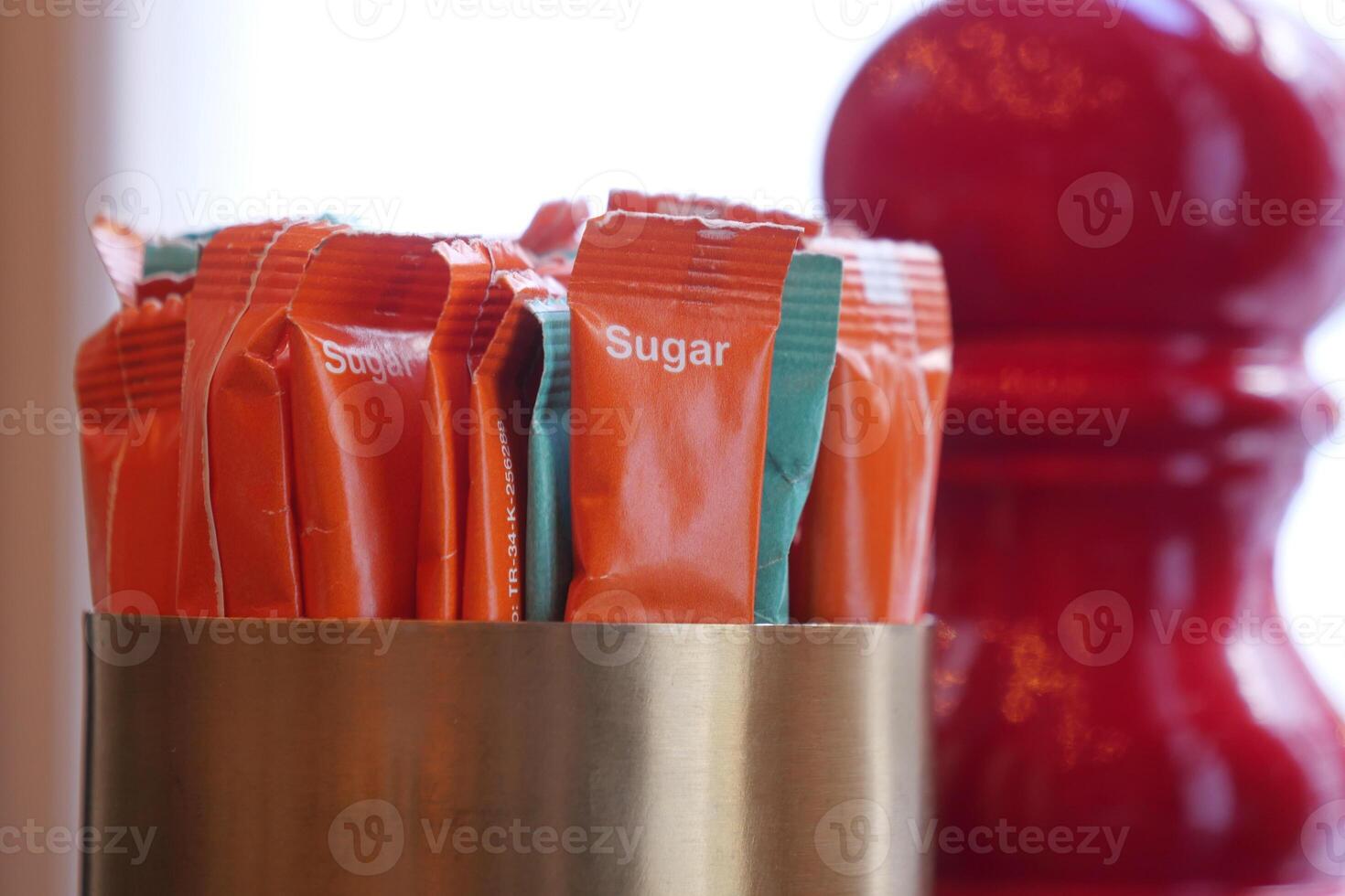 Colorful sugar packets in a container at a cafe table photo