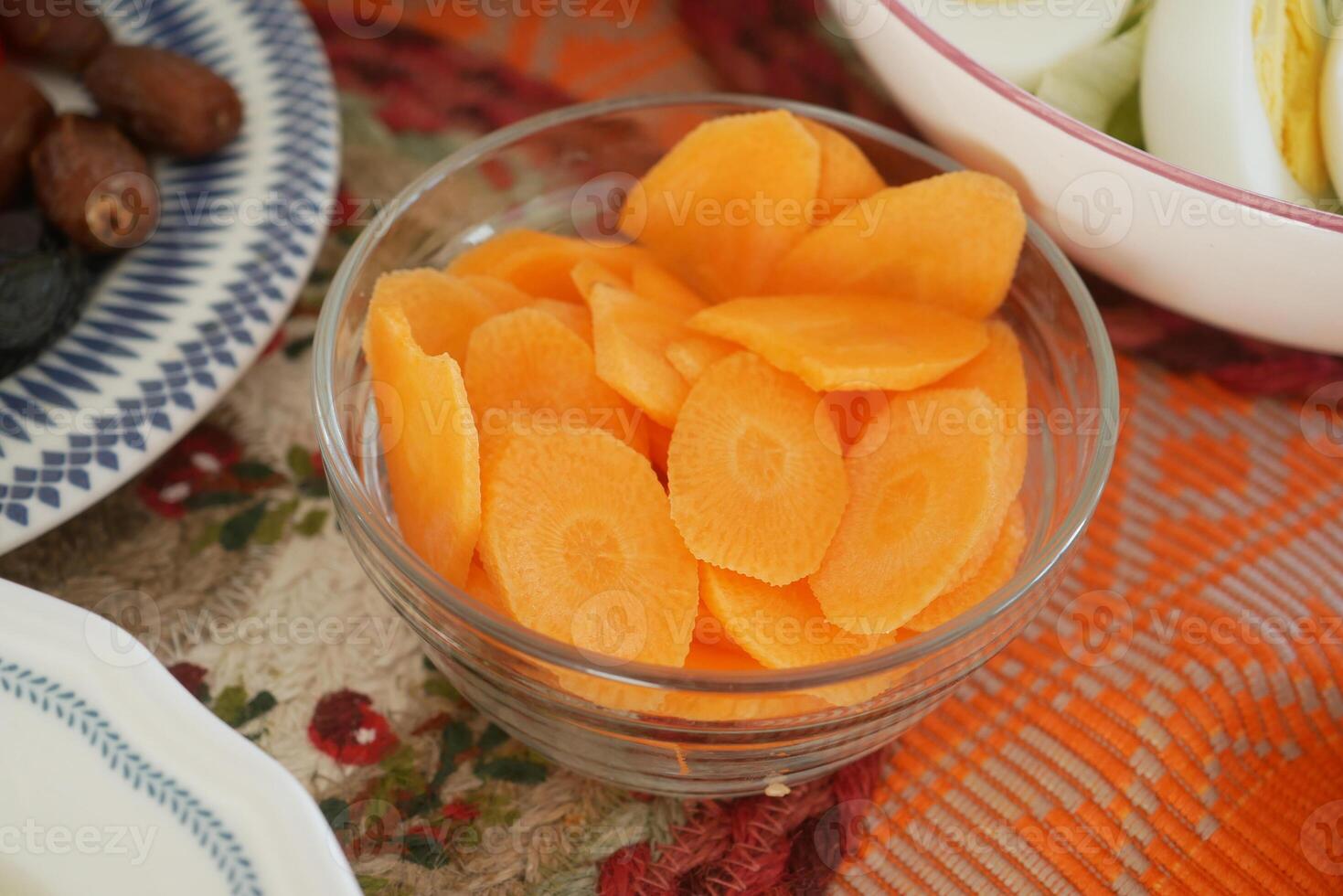Colorful carrot slices displayed in a traditional bowl photo