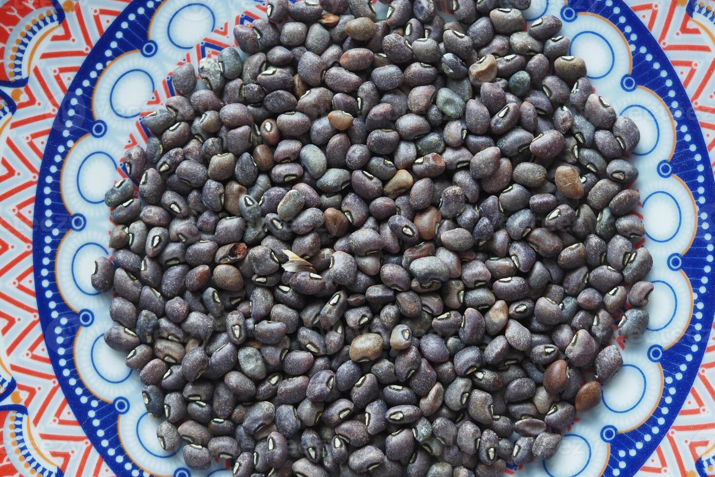 Black gram beans displayed on colorful patterned plate photo