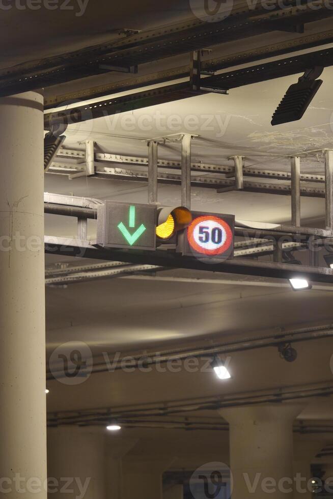 Traffic signals indicating speed limit and lane direction in a tunnel photo