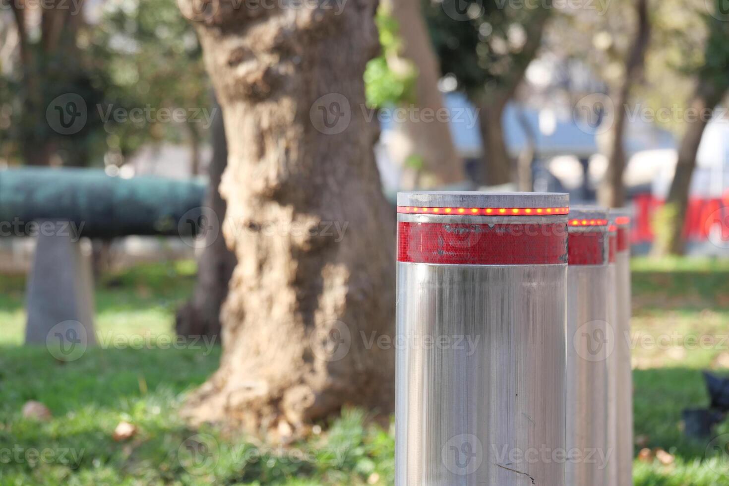 Metal Bollards with Red Lights in Urban Park Setting photo