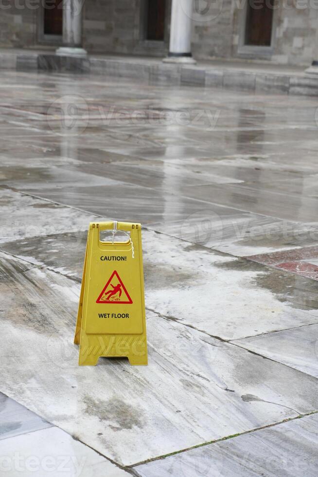 Caution sign indicating wet floor in a public building interior photo