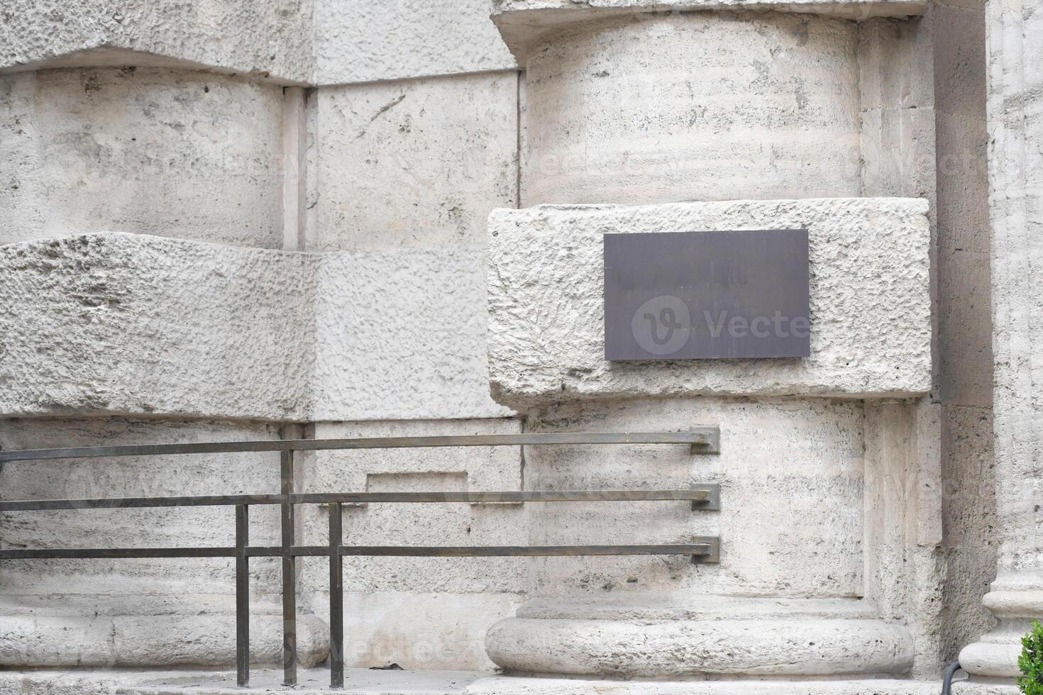 Historic building entrance with textured stone and handrails photo