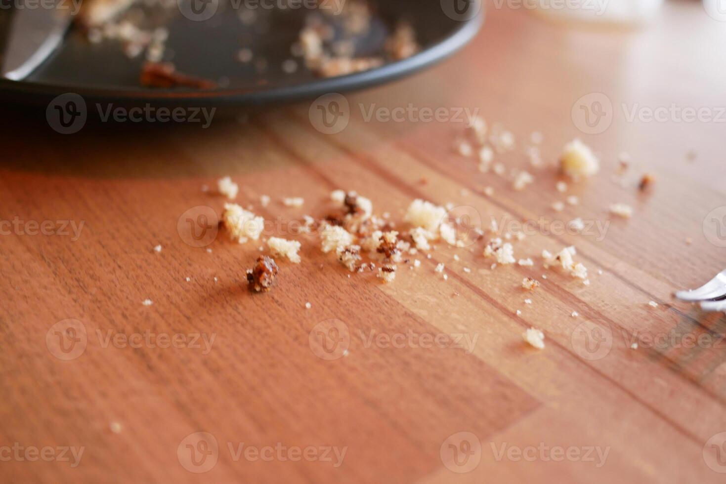 Crumbs scattered on a wooden table after enjoying a meal photo
