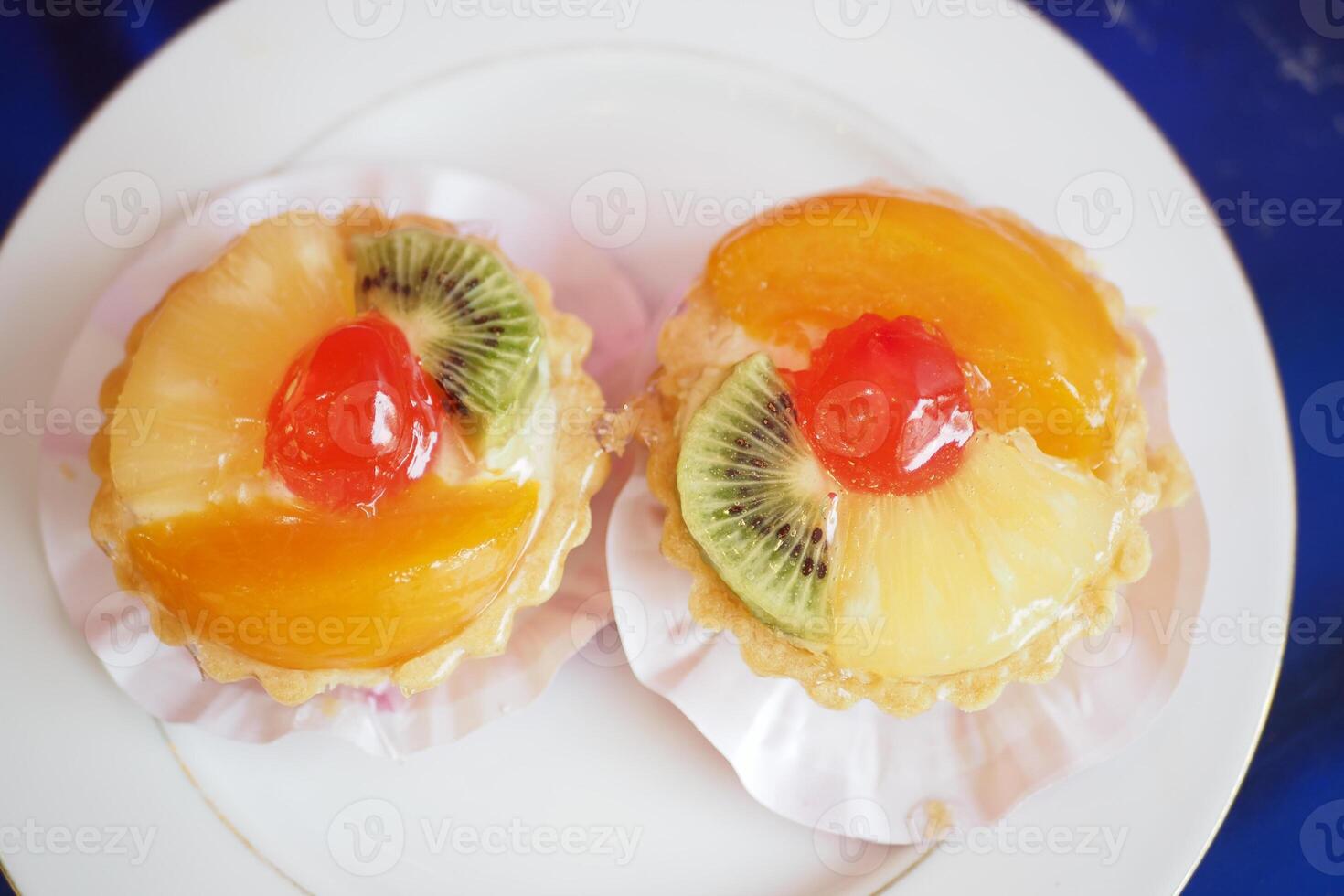 Delicious fruit tarts on a white plate at a dessert table photo