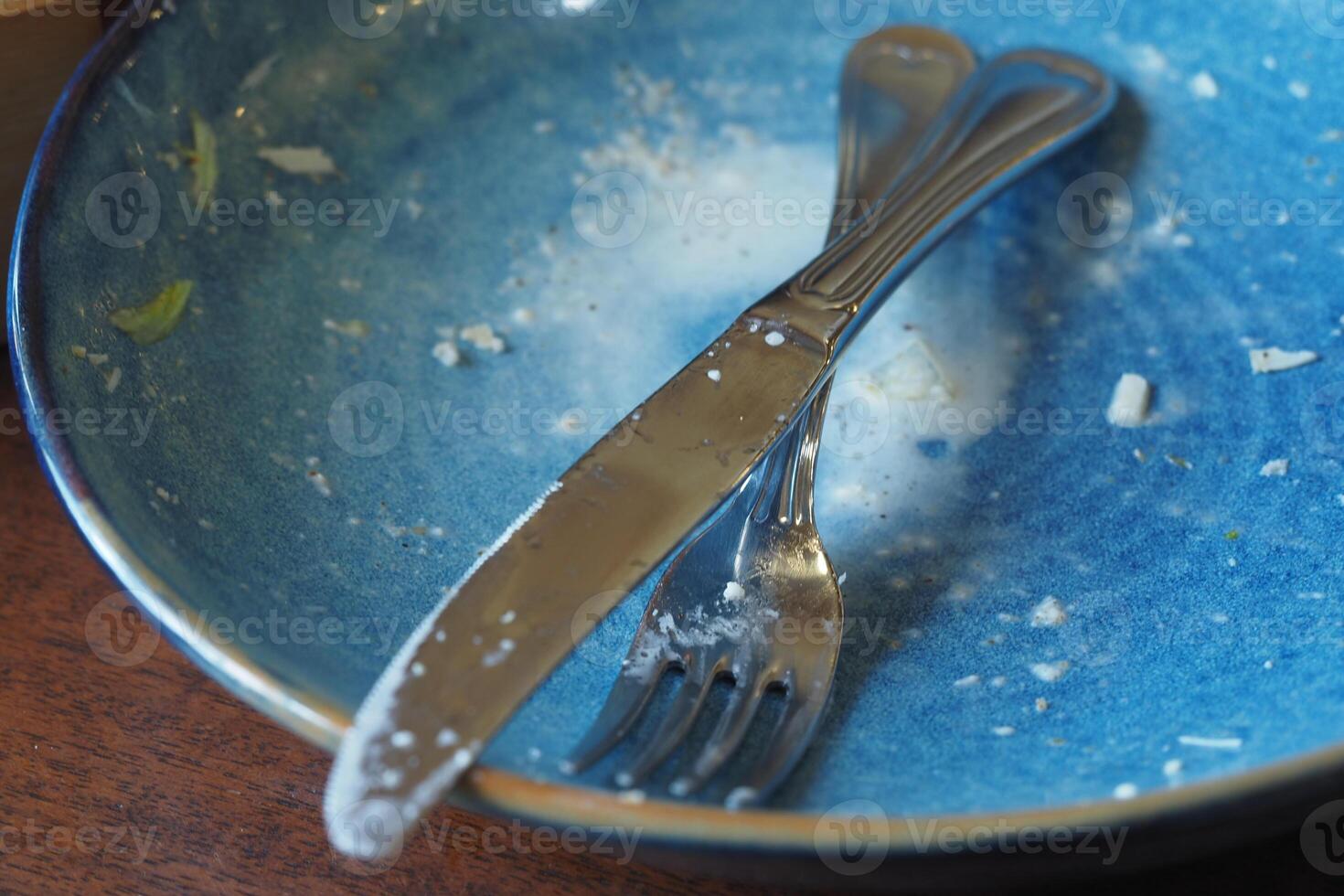 Empty plate with cutlery after a meal in a casual dining setting photo