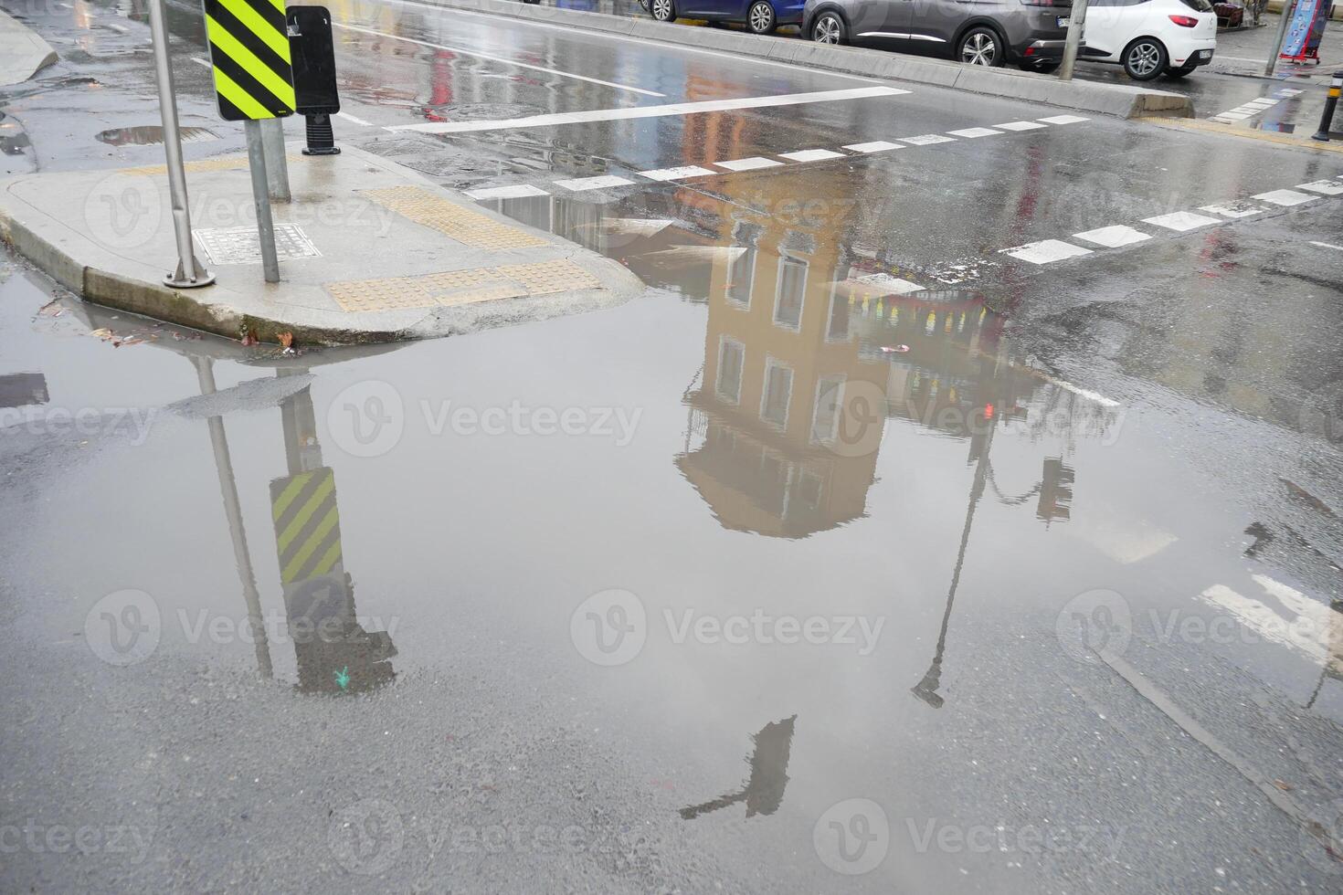 Reflections of a building in a rainwater puddle on the street photo