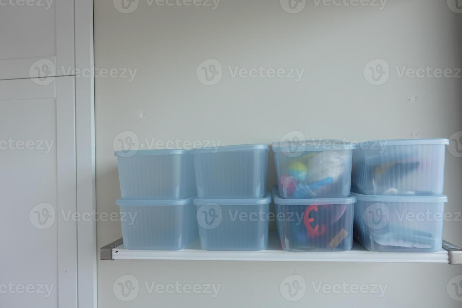 Organizing clear storage containers on a minimalist shelf photo