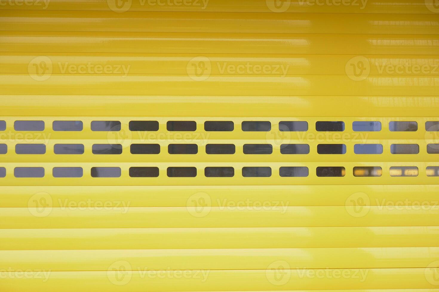 Bright yellow garage door with black windows in urban setting photo