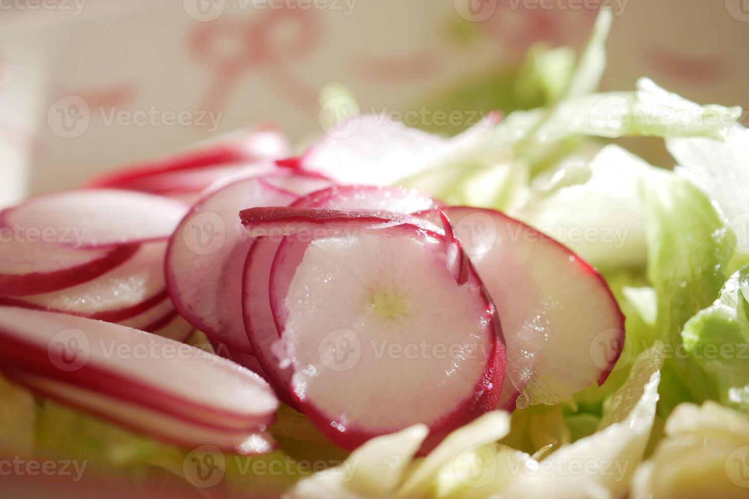 Freshly sliced radishes on a bed of crisp lettuce for a healthy salad photo