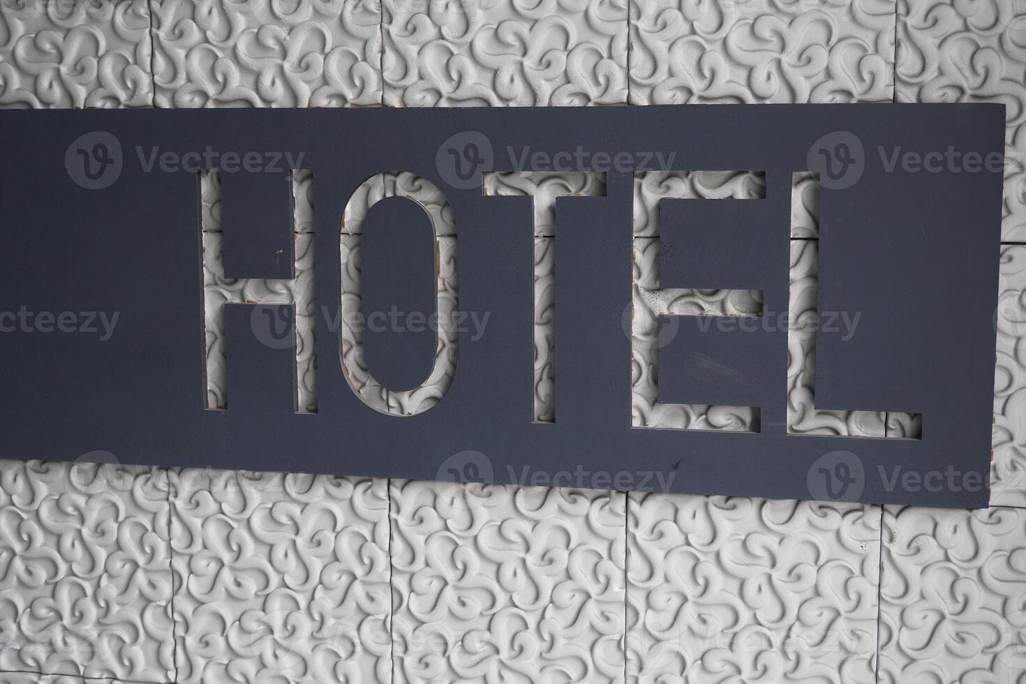 Modern hotel signage displayed on textured wall surface photo