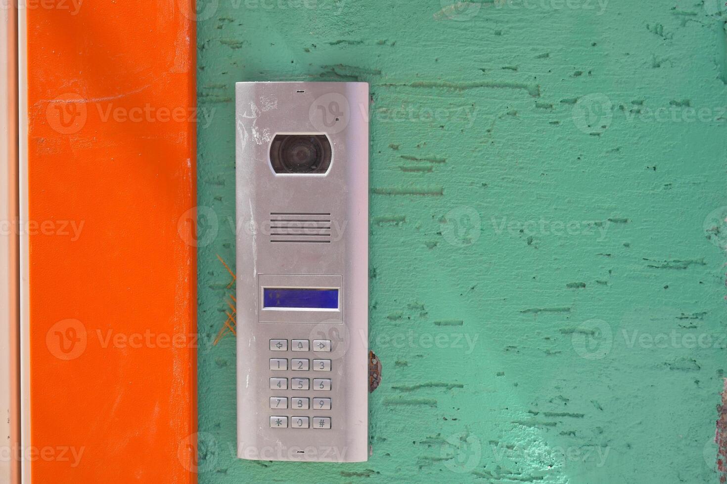 Modern intercom system mounted on a colorful wall in a urban setting photo