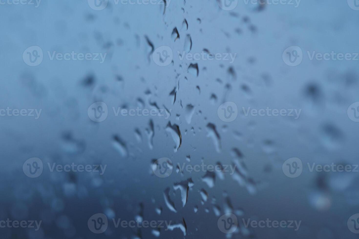 Raindrops on a window create a serene atmosphere during a rainy day photo