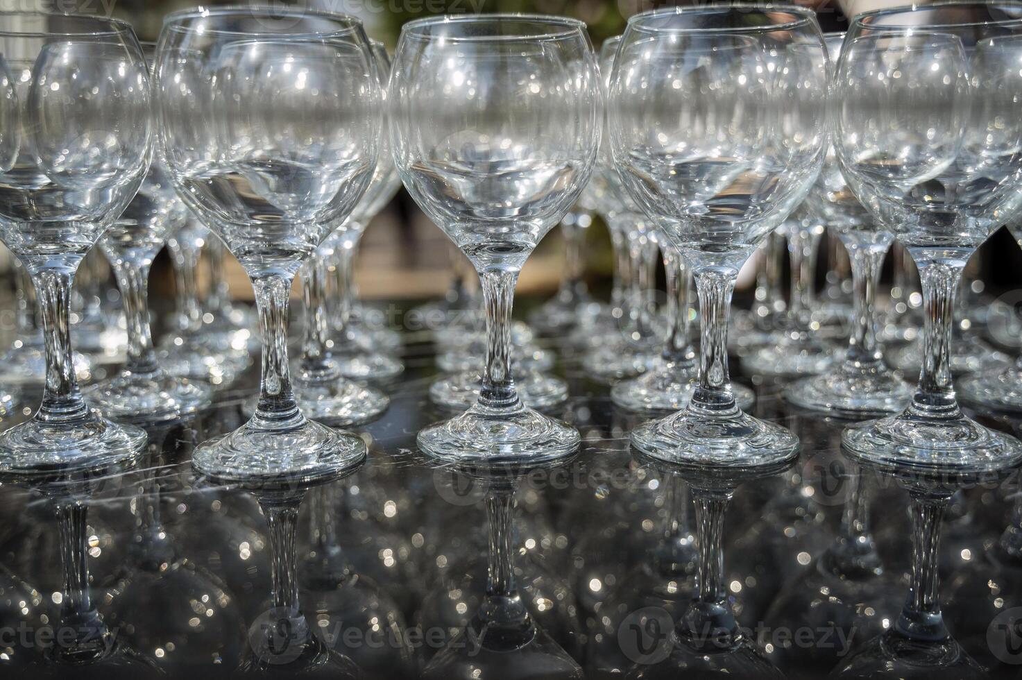 Many empty clean wine glasses on dark background in daylight. wine glasses, bar, glass, rows, empty glass, transparent, glass, many. Wine glasses on black background close-up photo