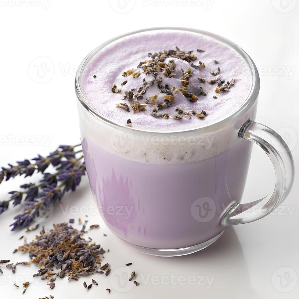 A glass mug filled with a frothy lavender honey latte topped with foam and seeds, in a white background photo