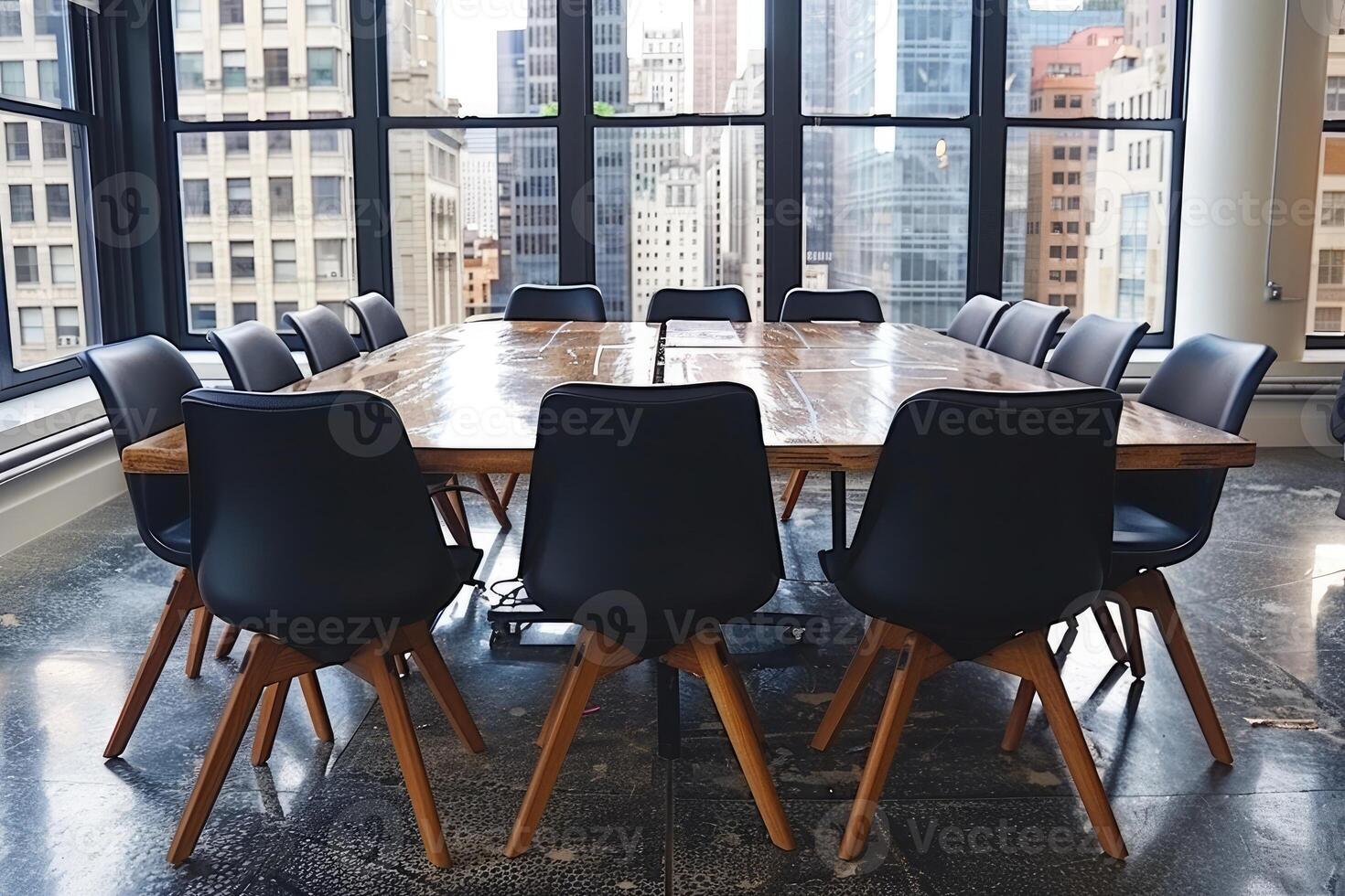 A conference table with black chairs in an office with a city view photo