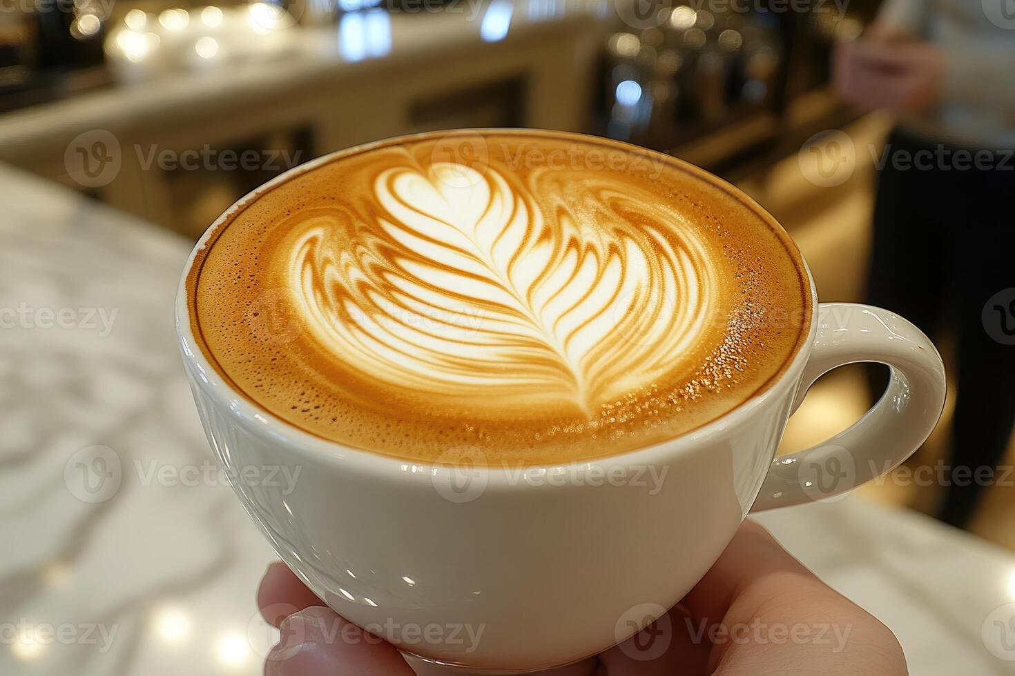 A Close-Up of a Latte with a Leaf Design in a White Cup photo