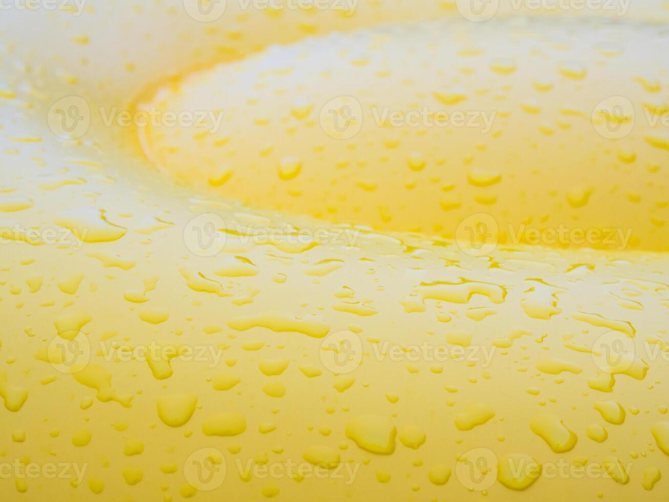 Water drops on surface of vivid yellow pool float photo