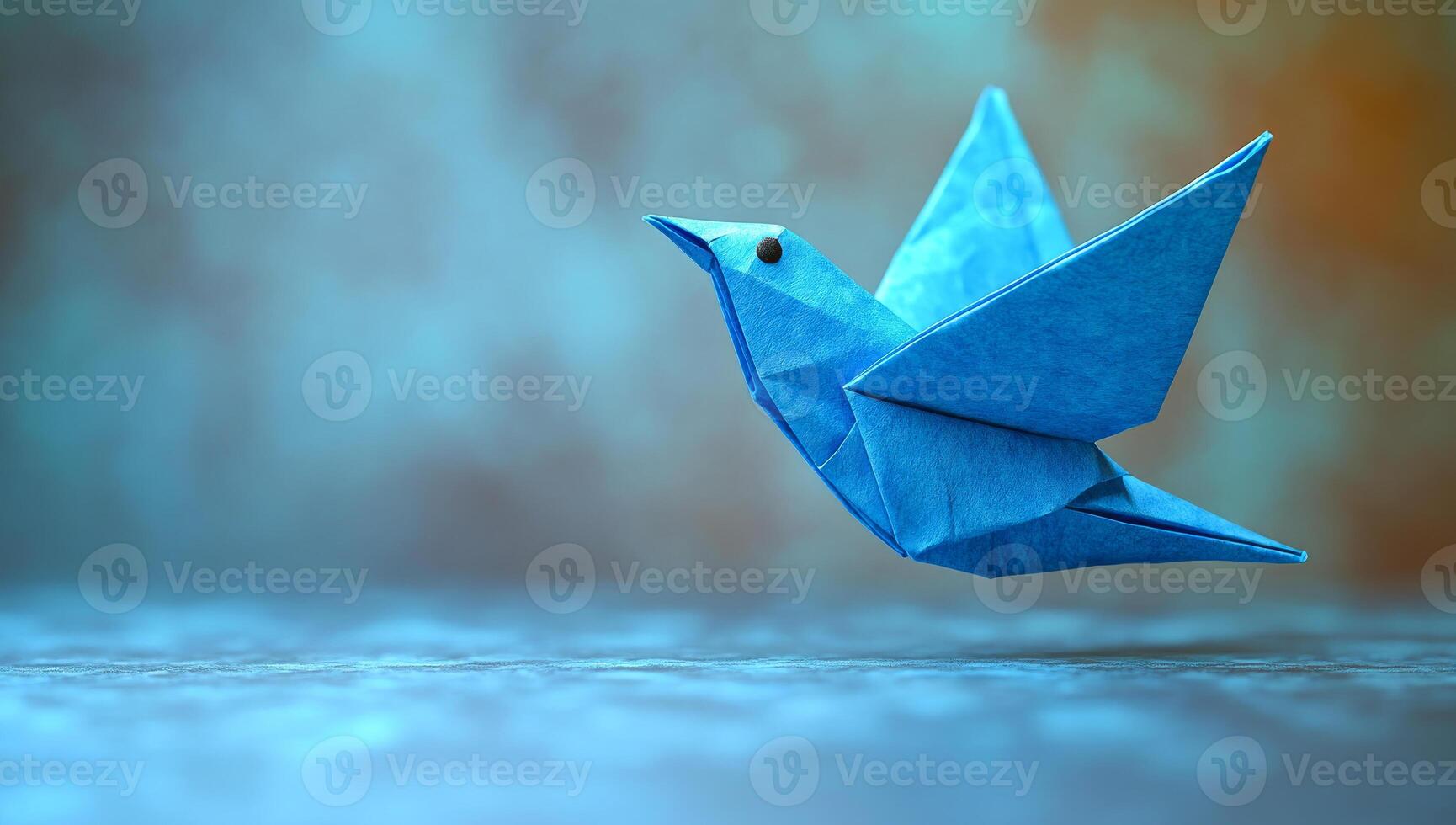 Blue origami bird in a serene setting. A delicate blue origami bird appears to soar over a softly blurred background, showcasing craftsmanship and creativity. photo