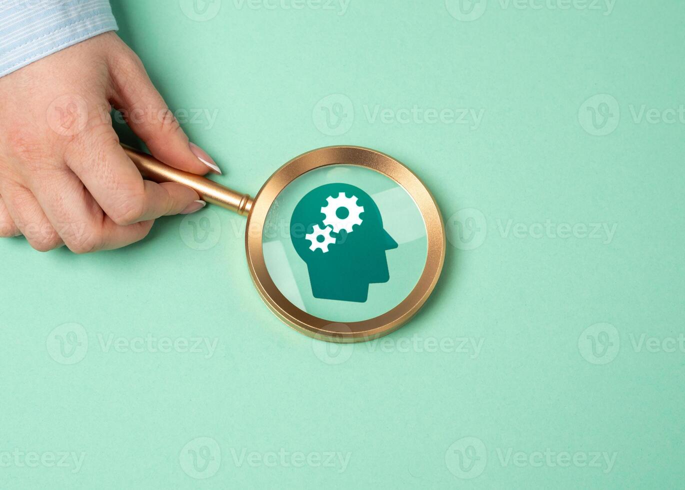 A magnifying glass points to the gears in a person's head. The concept of talent search and thinking development. Analyzing cognitive processes, discovering potential, intellectual growth. photo