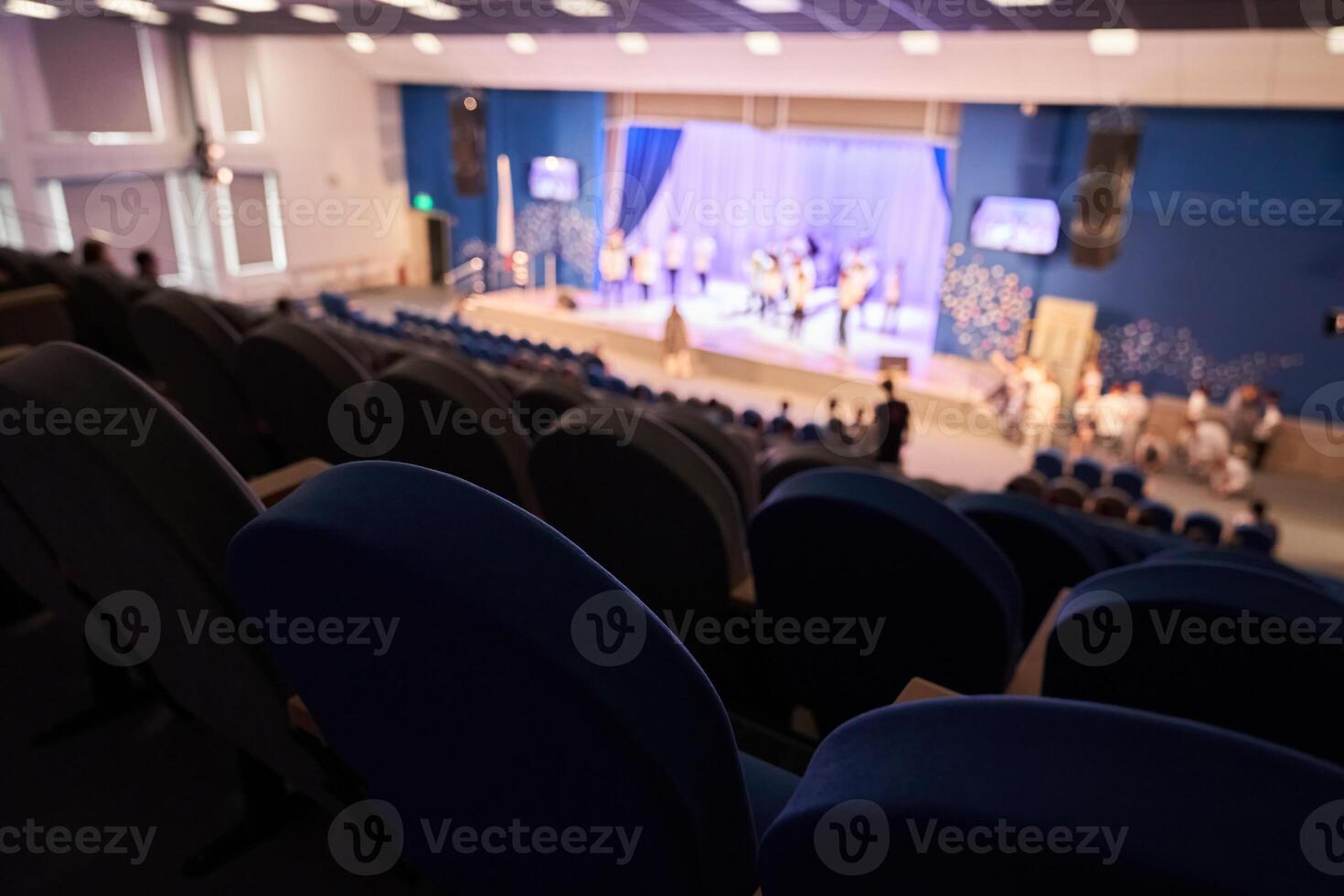 The rehearsal of the play. People in the auditorium are watching the performance. A music concert or festival. Out of focus. photo