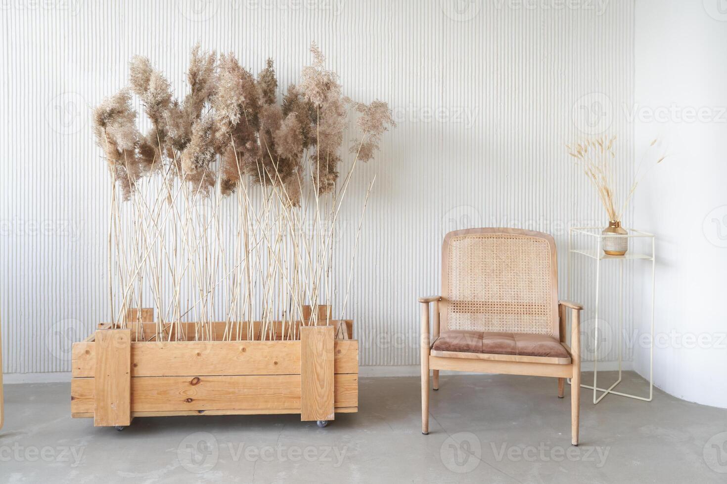 Dried flowers in a wooden box on the floor. Daylight from the window. Minimalism in the interior. Space for copying. A place for your design photo