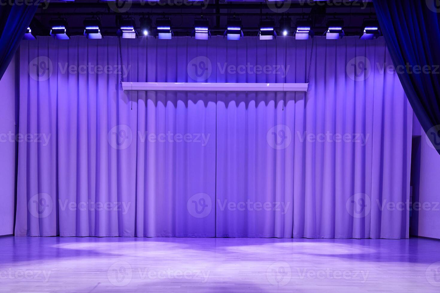 A podium stage with trendy purple lighting. Fabric wavy background with space for copying. An element for your design photo