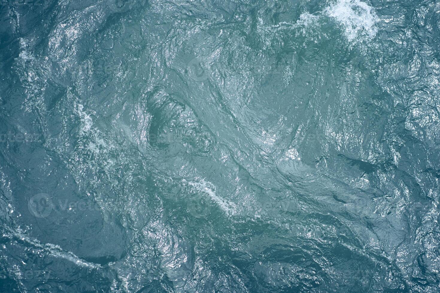 Blue water. Beautiful background with a place to copy. Close-up of raging waters. Ripples and waves on the water. photo