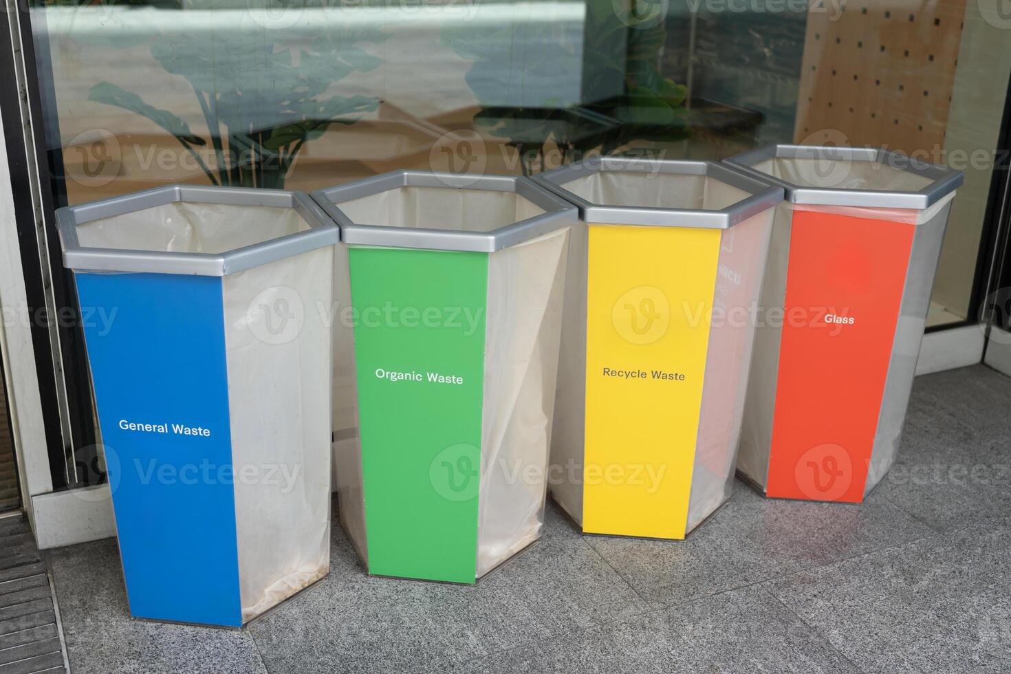 waste recycling management concept with green, blue, red and yellow bin on the ground. Collection of waste bins full of different types of garbage, recycling and separate waste collection concept. photo