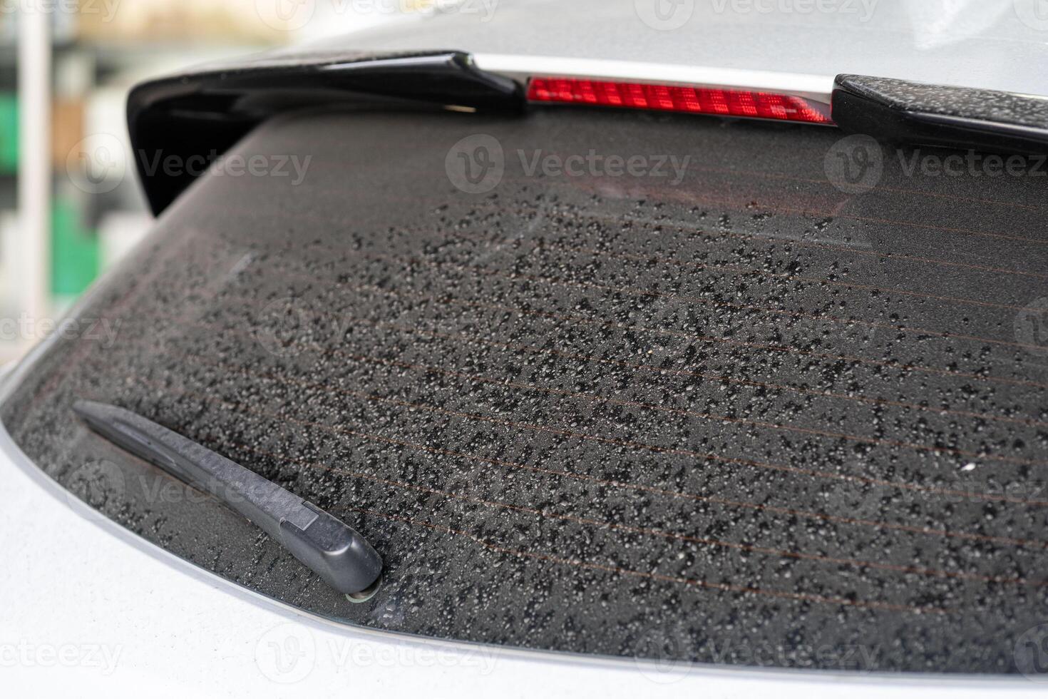 Rear window hatchback dirty car rear view on a dusty glass. Dirty and dusty rear window of a white or gray car. photo